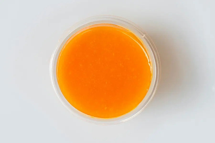 Orange fruit purée in a round container